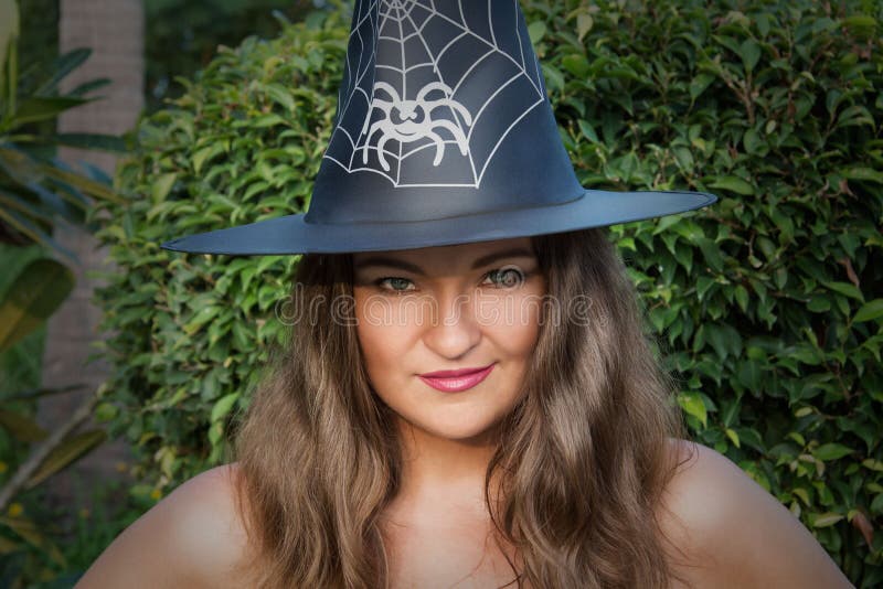 Beautiful young witch with green eyes and hat outdoors, toned with black vignette. Beautiful young witch with green eyes and hat outdoors, toned with black vignette