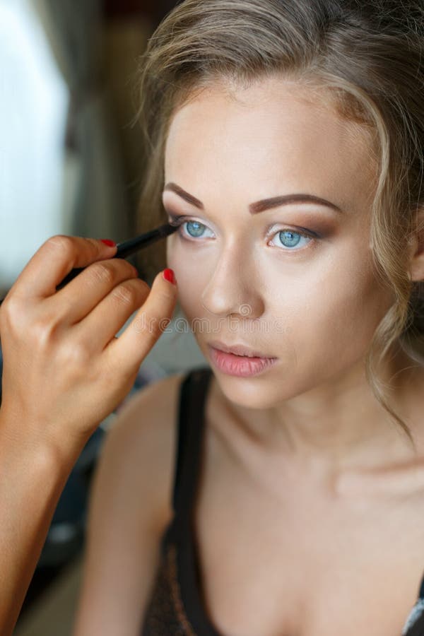 Belle nozze della sposa con trucco e l'acconciatura Lo stilista fa la sposa di trucco sul giorno delle nozze ritratto della giova fotografia stock libera da diritti Belle nozze della sposa con trucco e l'acconciatura Lo stilista fa la sposa di trucco sul giorno delle nozze ritratto della giova fotografia stock libera da diritti