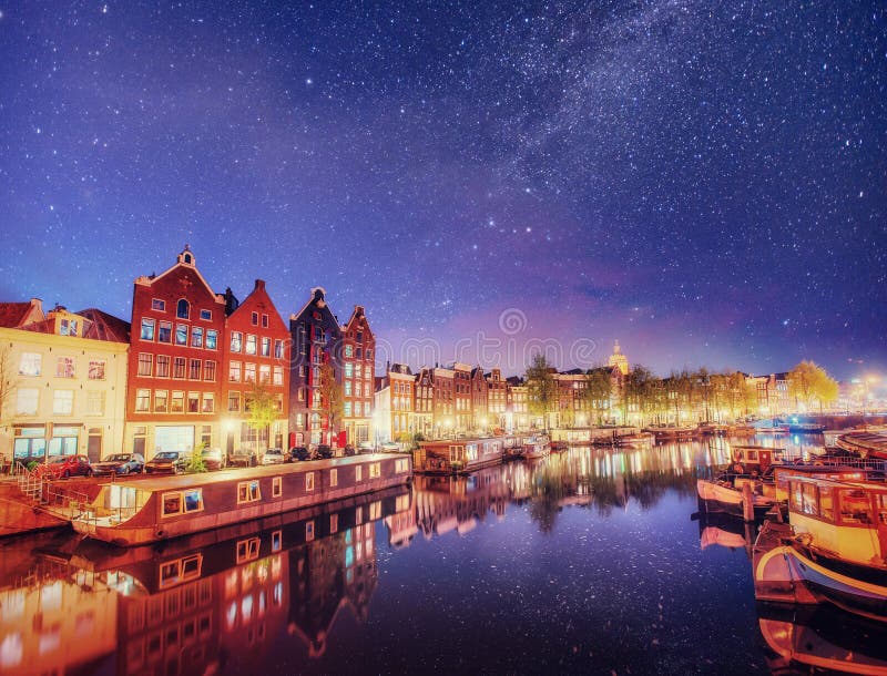 Belle nuit à Amsterdam Illumination de nuit des bâtiments et des bateaux près de l'eau dans le canal photo stock Belle nuit à Amsterdam Illumination de nuit des bâtiments et des bateaux près de l'eau dans le canal photo stock
