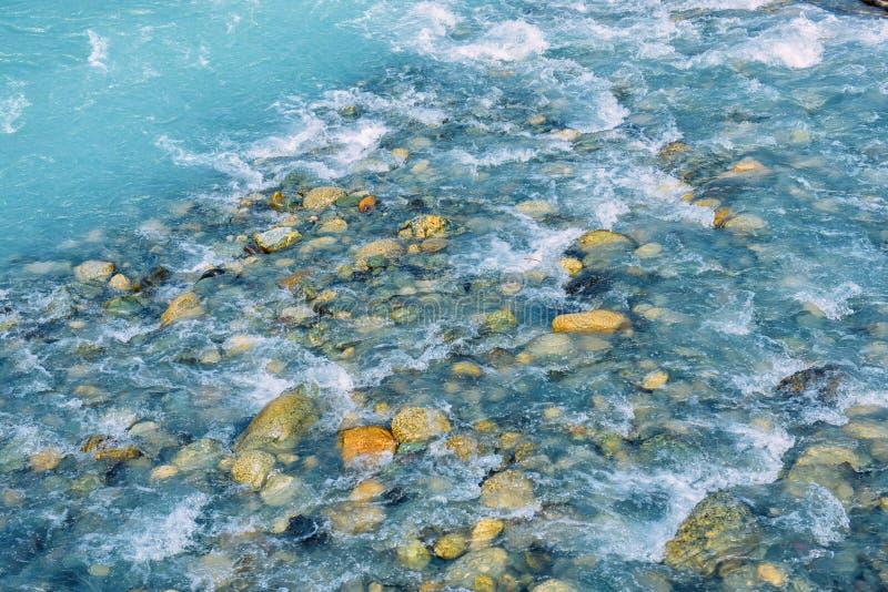 Belle ondulazioni su flusso del fiume sopra le pietre variopinte in sole di estate, Siberia, Repubblica di Altai immagine stock libera da diritti Belle ondulazioni su flusso del fiume sopra le pietre variopinte in sole di estate, Siberia, Repubblica di Altai immagine stock libera da diritti