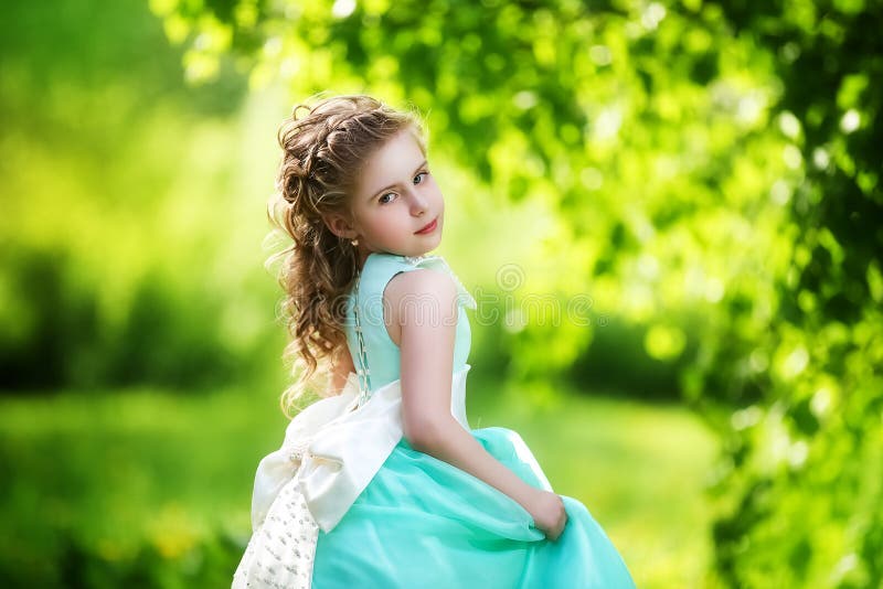 Belle petite fille dans une robe bleue avec un grand arc blanc dedans images libres de droits Belle petite fille dans une robe bleue avec un grand arc blanc dedans images libres de droits