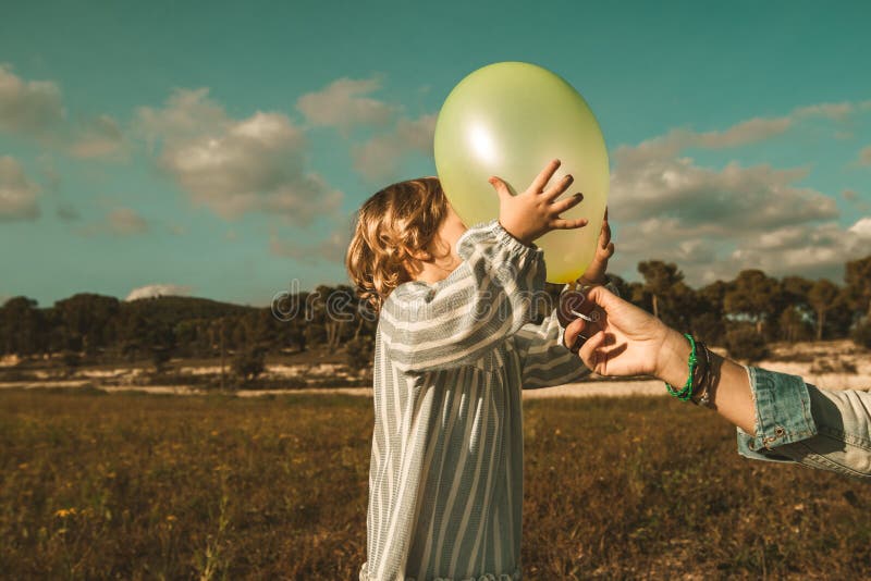 Belle petite fille jouant avec des ballons sur le champ image libre de droits Belle petite fille jouant avec des ballons sur le champ image libre de droits