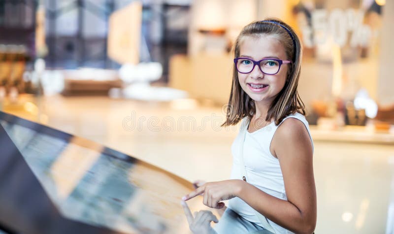 Belle petite fille mignonne étudiant le plan d'orientation dans le centre commercial Guide de magasin de centre commercial Techno images stock Belle petite fille mignonne étudiant le plan d'orientation dans le centre commercial Guide de magasin de centre commercial Techno images stock