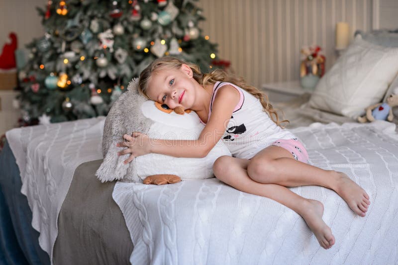 Belle petite fille s'asseyant près de l'arbre de Noël photo libre de droits