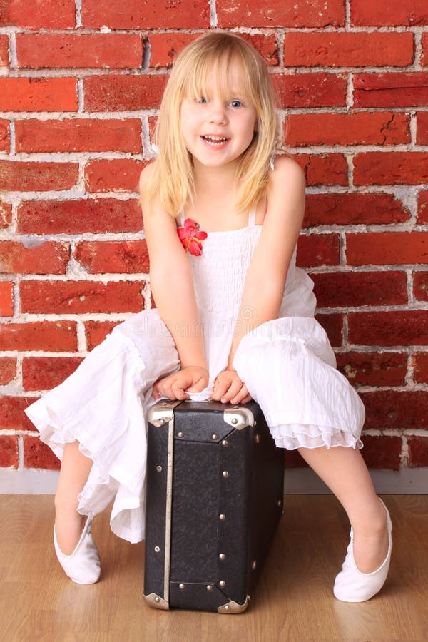 Belle petite fille s'asseyant sur un sac photo stock Belle petite fille s'asseyant sur un sac photo stock