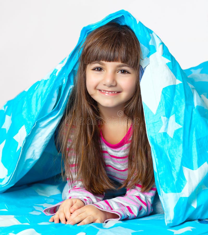 Belle petite fille se situant dans le bâti sous une couverture bleue images stock Belle petite fille se situant dans le bâti sous une couverture bleue images stock