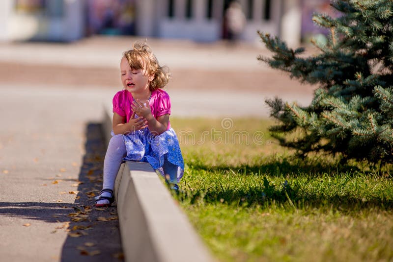 Belle petite fille triste pleurant, sur le fond d'été photographie stock libre de droits Belle petite fille triste pleurant, sur le fond d'été photographie stock libre de droits