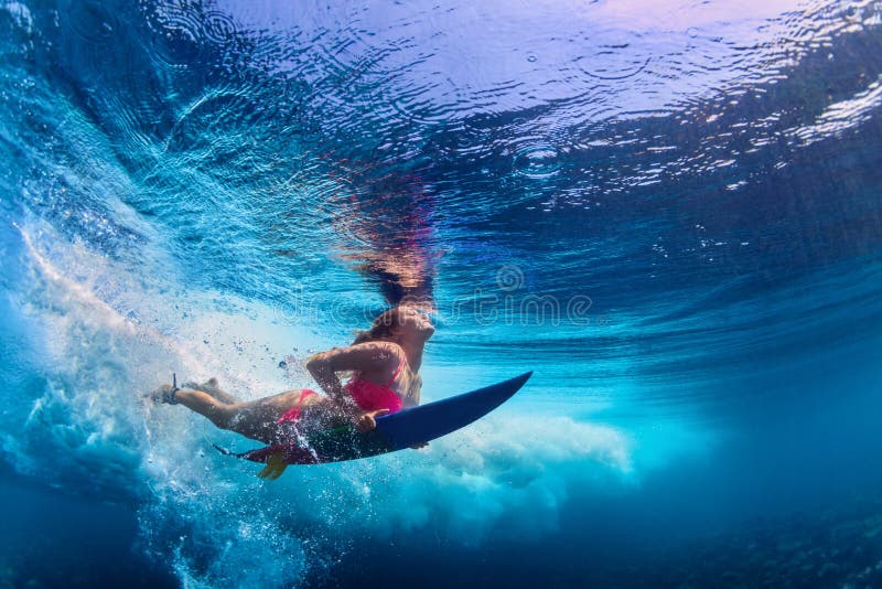 Belle plongée de fille de surfer sous l'eau avec le panneau de ressac photos libres de droits
