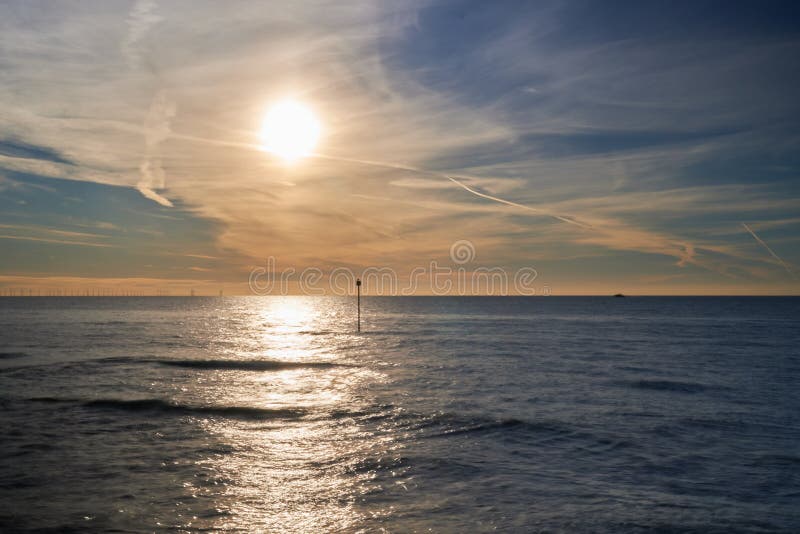 Une belle vue d'une mer calme avec le reflet d'un soleil radieux à la surface pendant le coucher du soleil