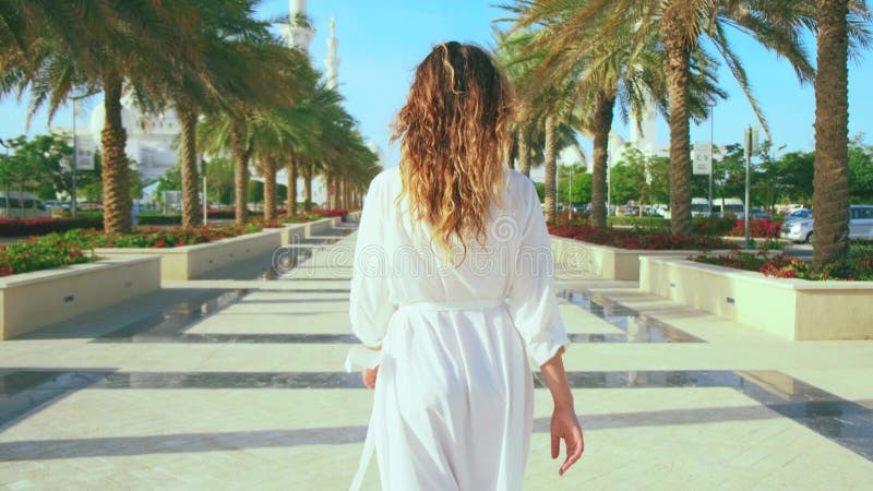 Belle vue magnifique ville touristique ville Abu Dhabi. Jeune femme touriste détournée se promenant le long de la ruelle de la vil banque de vidéos