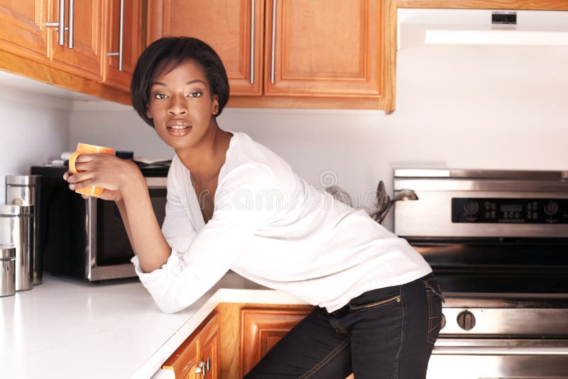 Belles femmes de couleur dans le sourire de cuisine photos stock Belles femmes de couleur dans le sourire de cuisine photos stock