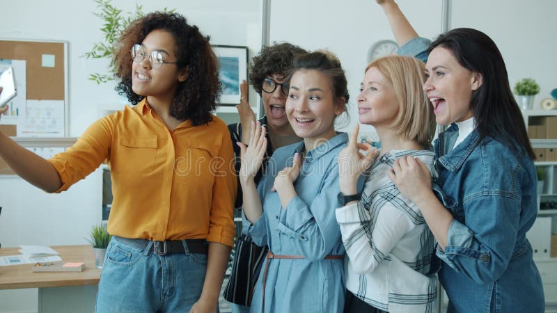 Belles femmes mixte race groupe prenant selfie avec smartphone caméra au travail banque de vidéos
