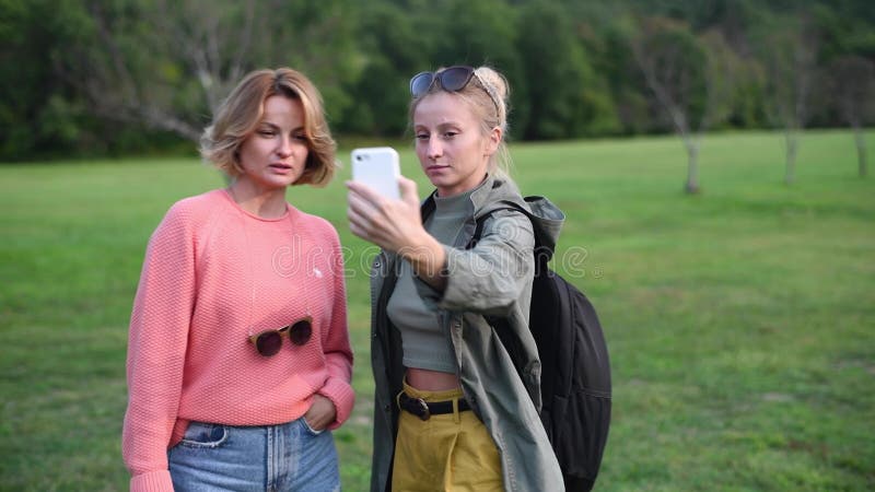 Belles femmes prenant le selfie avec le téléphone intelligent dans le parc clips vidéos