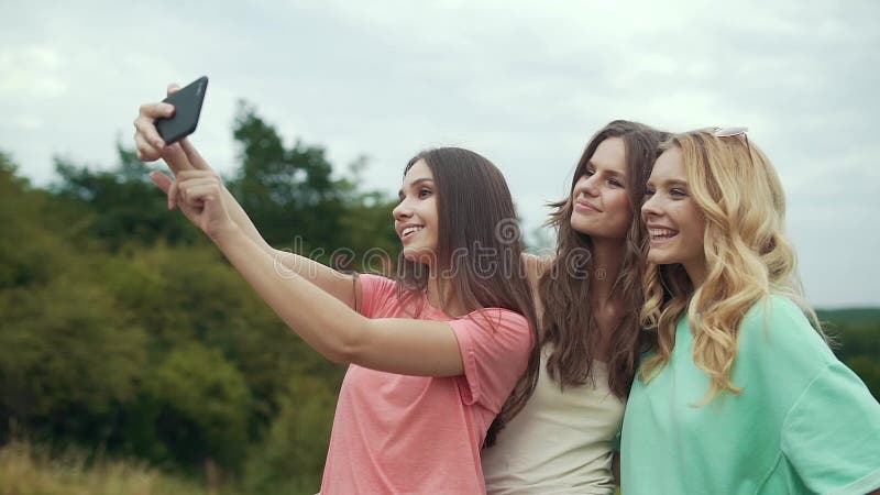 Belles filles prenant des photos au téléphone en nature