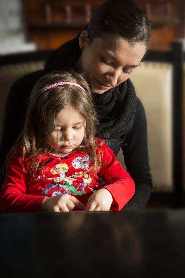 Belles jeunes femmes avec la fille assez petite dans des ses bras photographie stock libre de droits Belles jeunes femmes avec la fille assez petite dans des ses bras photographie stock libre de droits