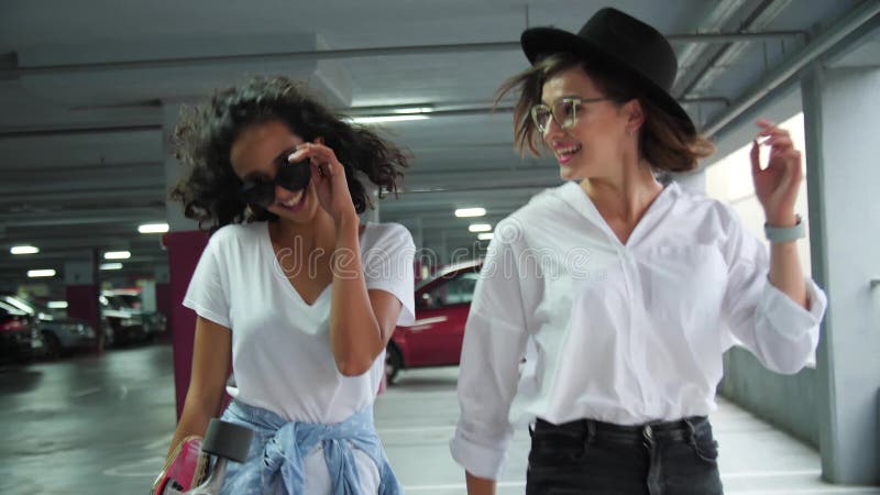 Belles jeunes femmes ayant l'amusement au parking banque de vidéos
