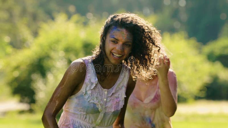 Belles jeunes femmes étreignant et souriant, l'eau éclaboussant sur les dames heureuses banque de vidéos