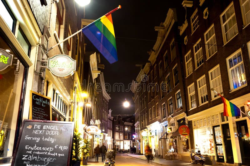 Belles petites maisons et barre traditionnelles avec le symbole de LGBT à Amsterdam par nuit M photos stock Belles petites maisons et barre traditionnelles avec le symbole de LGBT à Amsterdam par nuit M photos stock