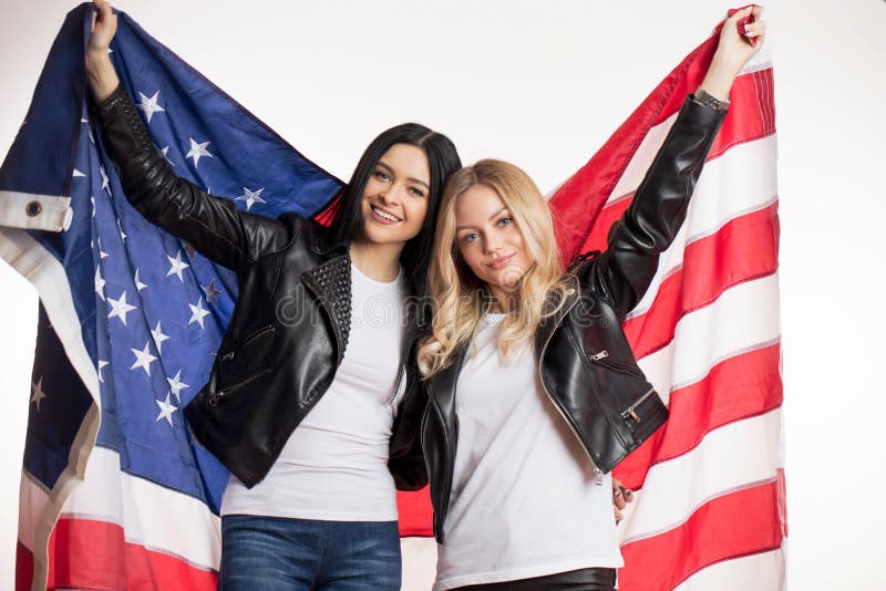 Belli castana e biondi stanno tenendo la bandiera di U.S.A. fotografie stock Belli castana e biondi stanno tenendo la bandiera di U.S.A. fotografie stock