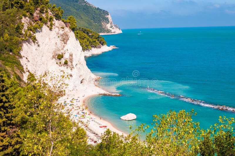 Bellissima costa di Numana, Ancona, Italia circondata da alte rocce di calcare bianco ermetiche erose erbacce dalle onde adriatic fotografia stock Bellissima costa di Numana, Ancona, Italia circondata da alte rocce di calcare bianco ermetiche erose erbacce dalle onde adriatic fotografia stock