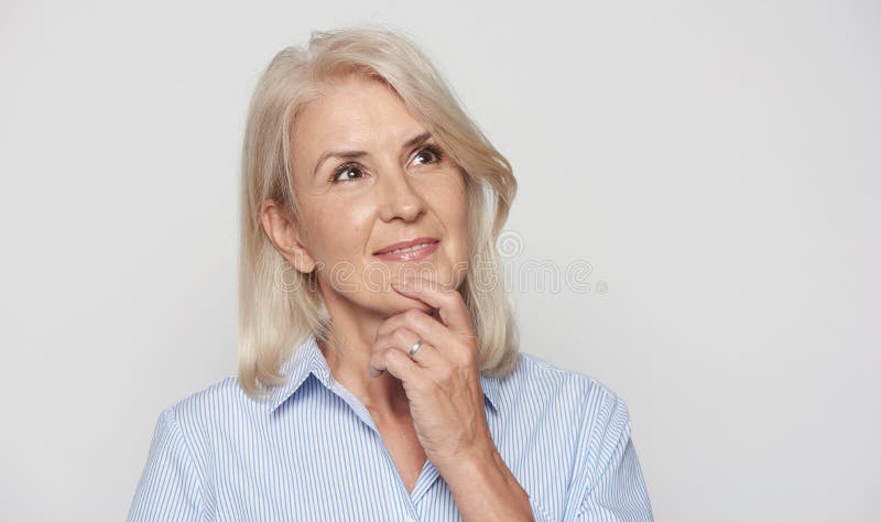 Bellissima donna bionda di 50 anni che guarda e sogna immagini stock libere da diritti Bellissima donna bionda di 50 anni che guarda e sogna immagini stock libere da diritti
