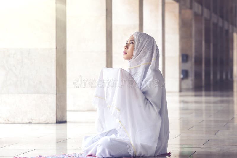 Bellissima donna musulmana che prega nella moschea fotografia stock Bellissima donna musulmana che prega nella moschea fotografia stock