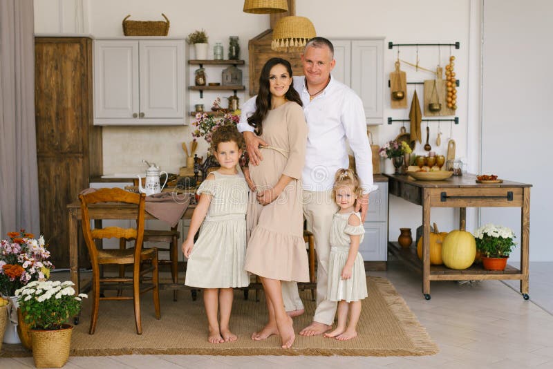 Bellissima famiglia con due figlie sorridenti in cucina, madre incinta fotografia stock libera da diritti Bellissima famiglia con due figlie sorridenti in cucina, madre incinta fotografia stock libera da diritti