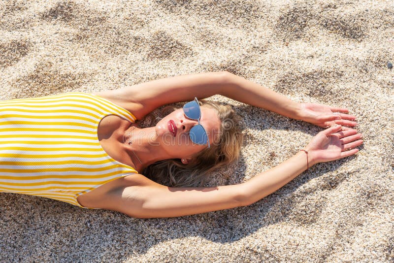 Bellissima modella di moda sdraiata sulla sabbia Concetto estivo della moda immagine stock libera da diritti