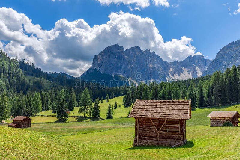 Bellissimo paesaggio alpino con prati appena tagliati sullo sfondo delle montagne Dolomite italiane fotografia stock Bellissimo paesaggio alpino con prati appena tagliati sullo sfondo delle montagne Dolomite italiane fotografia stock