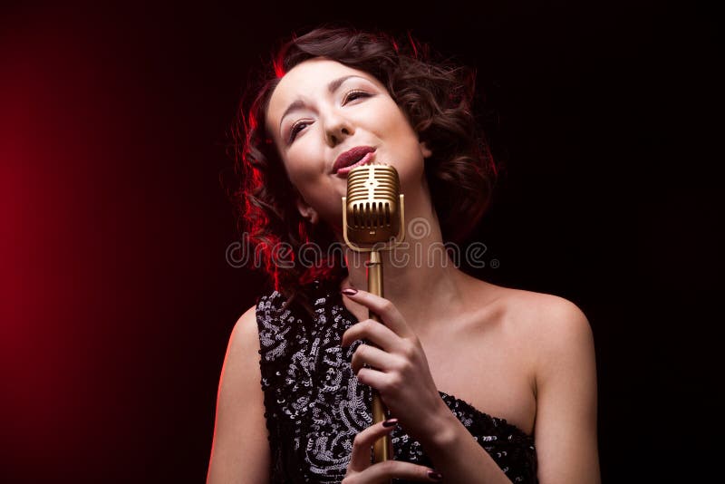 Bello cantante della ragazza che canta canzone lirica con il retro microfono immagini stock libere da diritti Bello cantante della ragazza che canta canzone lirica con il retro microfono immagini stock libere da diritti