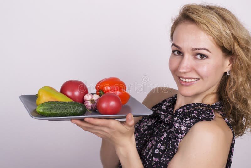 Bello cibo della giovane donna verdure tenuta del piatto con le verdure, peperone, pomodoro, cetriolo Alimento sano immagini stock libere da diritti Bello cibo della giovane donna verdure tenuta del piatto con le verdure, peperone, pomodoro, cetriolo Alimento sano immagini stock libere da diritti