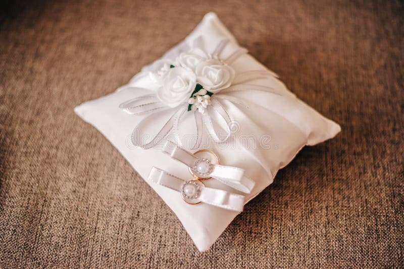 Bello cuscino bianco molle per le fedi nuziali fotografie stock Bello cuscino bianco molle per le fedi nuziali fotografie stock