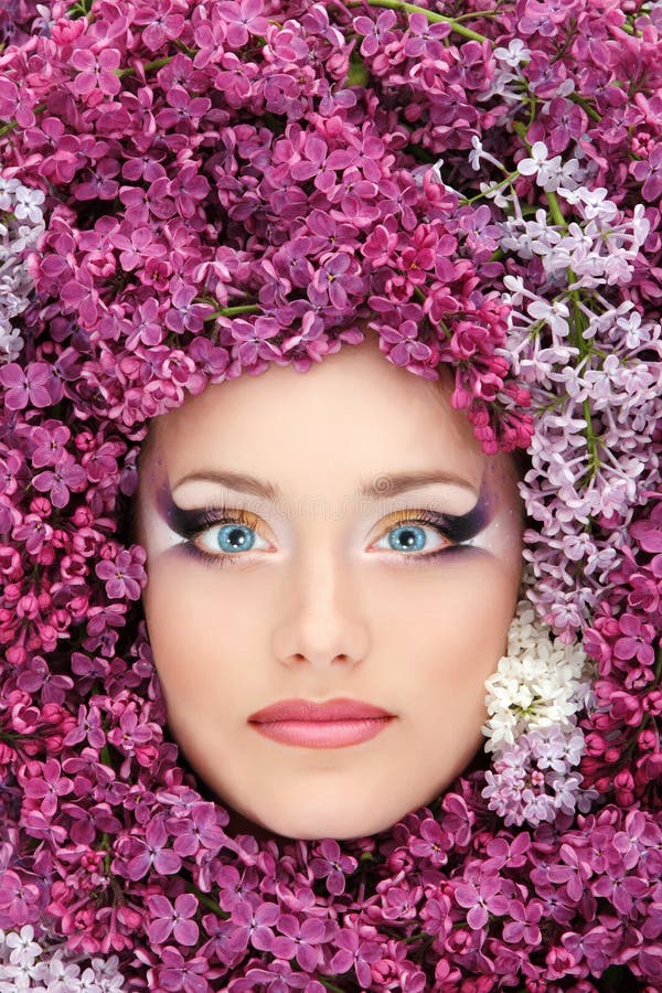 Bello fronte della donna con il bordo del lillà del fiore