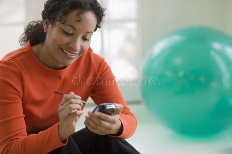 Bello invio di messaggi di testo della donna sul telefono delle cellule immagini stock Bello invio di messaggi di testo della donna sul telefono delle cellule immagini stock
