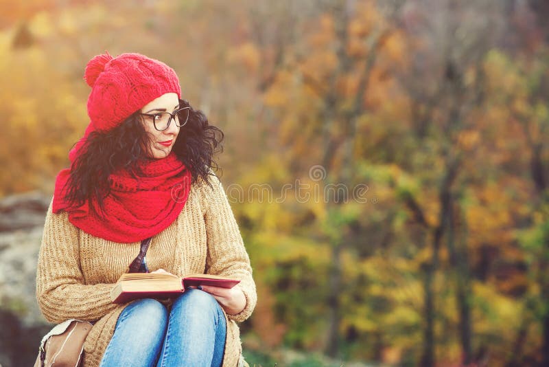 Bello libro di lettura della giovane donna in un parco e nel godere del tempo soleggiato Concetto di autunno e di stile di vita fotografie stock Bello libro di lettura della giovane donna in un parco e nel godere del tempo soleggiato Concetto di autunno e di stile di vita fotografie stock