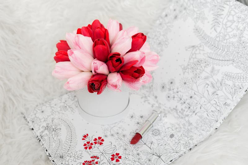 Bello mazzo dei fiori in un contenitore rotondo di cappello su una tavola fotografia stock libera da diritti Bello mazzo dei fiori in un contenitore rotondo di cappello su una tavola fotografia stock libera da diritti
