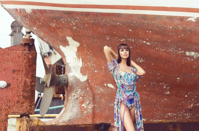 Bello, modello di moda sensuale e sexy che posa davanti alla vecchia barca arrugginita immagine stock libera da diritti Bello, modello di moda sensuale e sexy che posa davanti alla vecchia barca arrugginita immagine stock libera da diritti