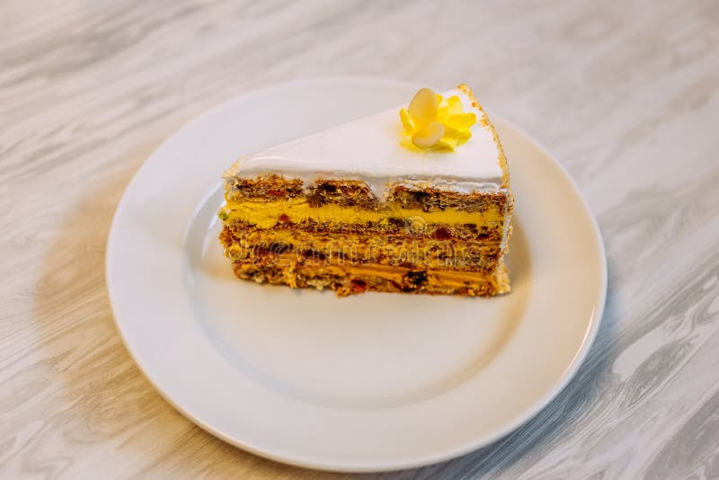 Bello pezzo del biscotto di dolce con i dadi, la frutta, la crema e la crema della proteina sulla tavola immagine stock libera da diritti Bello pezzo del biscotto di dolce con i dadi, la frutta, la crema e la crema della proteina sulla tavola immagine stock libera da diritti