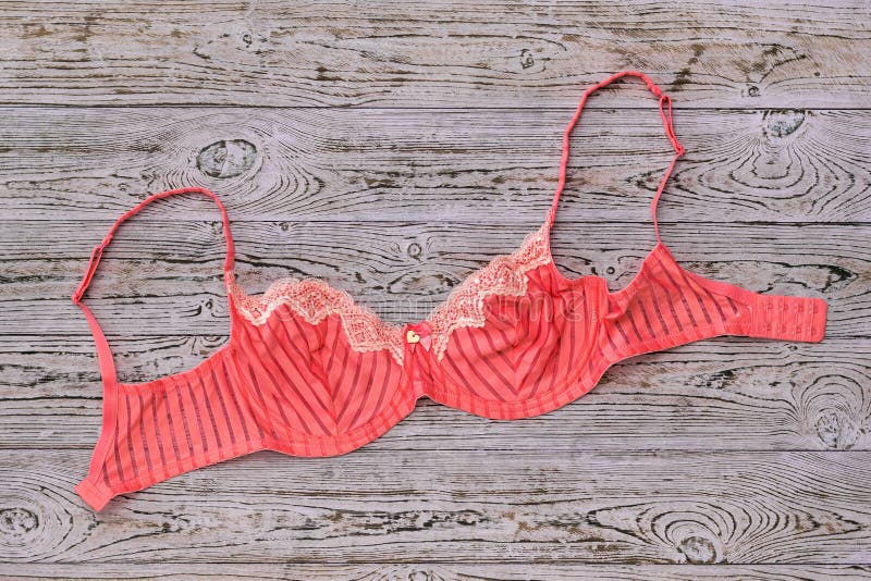 Bello reggiseno rosso-chiaro su fondo di legno immagini stock Bello reggiseno rosso-chiaro su fondo di legno immagini stock