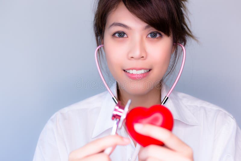 Bello stetoscopio di uso della donna per il controllo del cuore falso fotografia stock libera da diritti Bello stetoscopio di uso della donna per il controllo del cuore falso fotografia stock libera da diritti