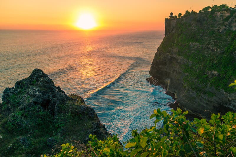 Bello tramonto sui precedenti del mare e delle rocce al tempio di Uluwatu, Bali, Indonesia fotografia stock Bello tramonto sui precedenti del mare e delle rocce al tempio di Uluwatu, Bali, Indonesia fotografia stock