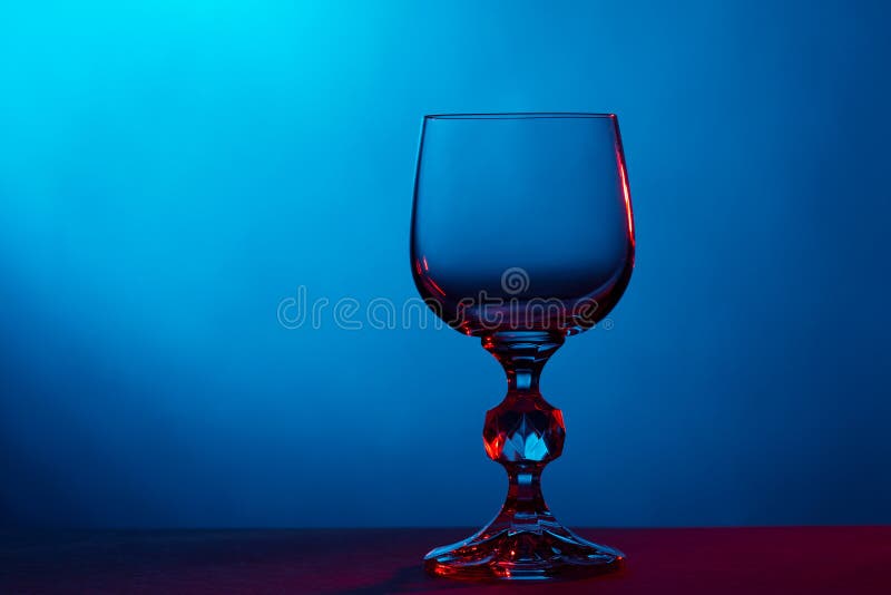 Bello vetro di vino su fondo blu immagine stock Bello vetro di vino su fondo blu immagine stock