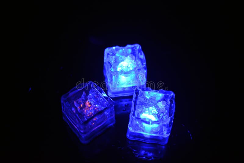 Bello y brillante cubo de hielo azul flotante en una copa de champán de vidrio con una bebida. fotografía de archivo libre de regalías