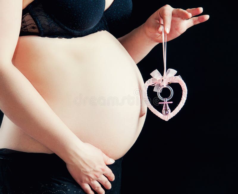 Belly сердце конца-вверх и игрушки с ниппелью младенца стоковые фотографии rf
