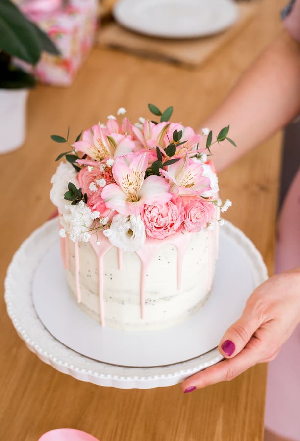 Feminino mão decorando o bolo de aniversário de casamento flor