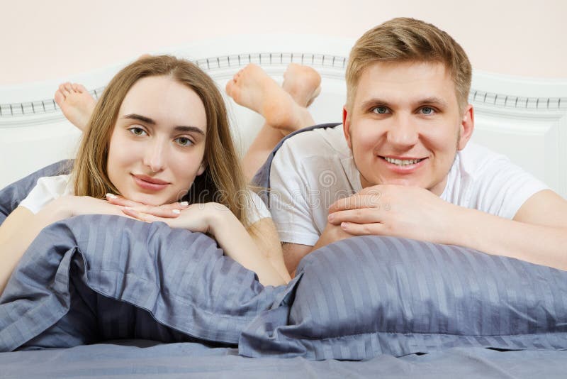 Belo casal romântico na cama, relação feliz, casal heterossexual imagem de stock Belo casal romântico na cama, relação feliz, casal heterossexual imagem de stock