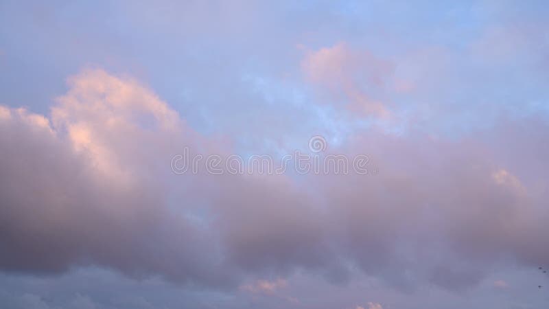 Belo céu azul à noite no pôr do sol com nuvens luminosas brilhantes e brilhantes iluminadas por raios de luz solar que flutuam len