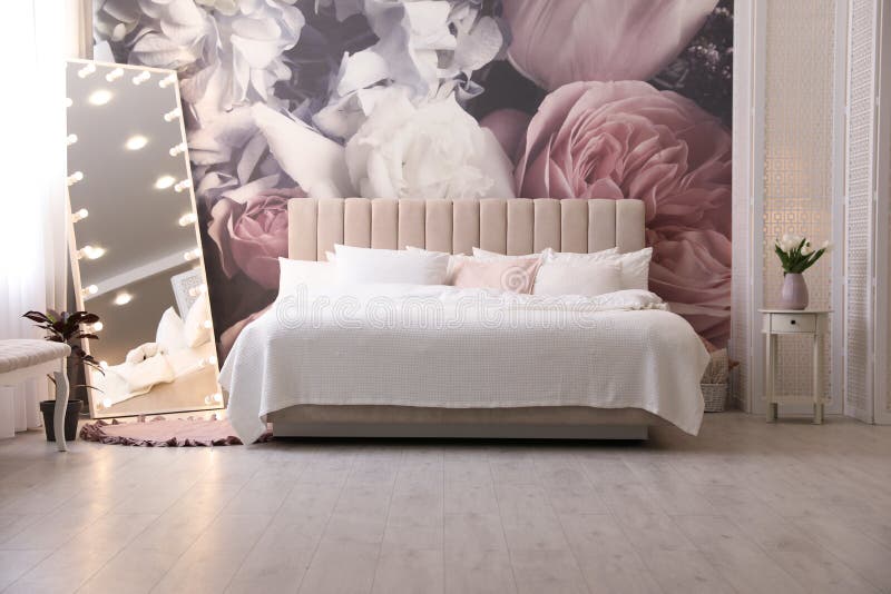 Belo interior de quarto com espelho-cama e padrão floral na parede fotografia de stock royalty free