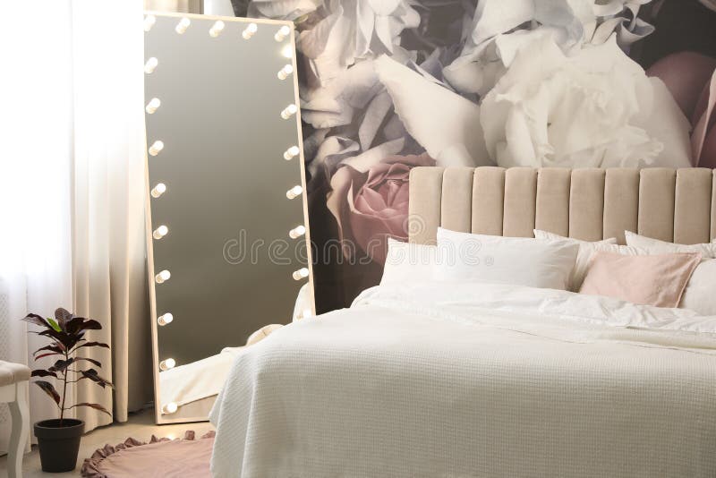 Belo interior de quarto com espelho-cama e padrão floral na parede imagens de stock royalty free