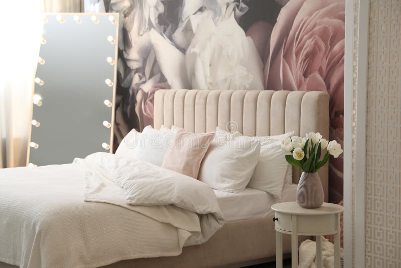 Belo interior de quarto com espelho-cama e padrão floral na parede imagens de stock
